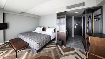 Un dormitorio moderno con una cama grande, un banco, un armario y un televisor en la pared.