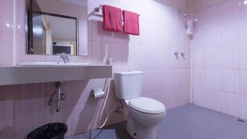 A bathroom with a white sink, a toilet, and a shower area.