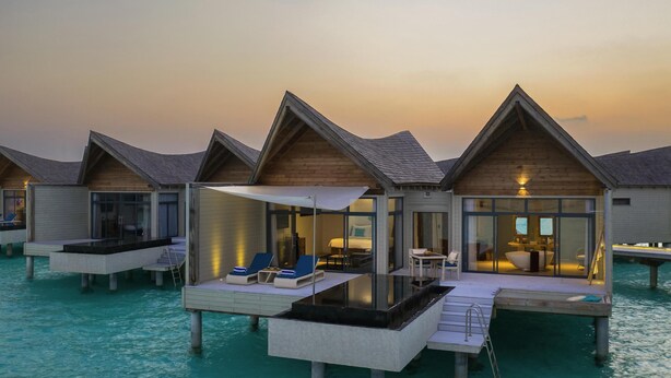 Overwater bungalows with private pools, wooden architecture, and glass enclosures. - Kuredhivaru Resort & Spa Maldives by Accor (Kuredhivaru)