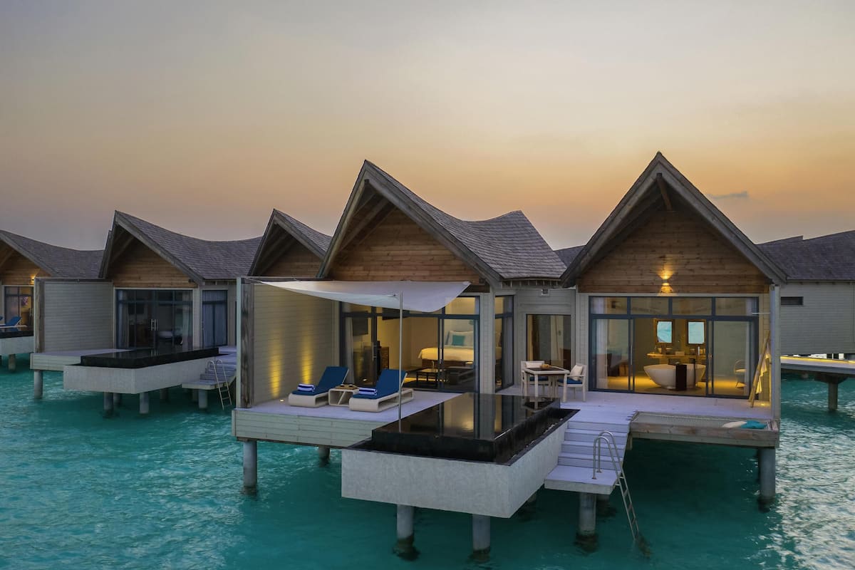 Bungalows sur pilotis dotés de piscines privées, d’une architecture en bois et de baies vitrées.