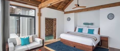Un dormitorio amplio con una cama grande, techo de madera y vista a una piscina a través de un ventanal.