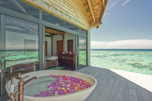 A modern infinity pool with a jacuzzi, surrounded by a wooden deck and glass walls offering a view of the ocean. - Kuredhivaru Resort & Spa Maldives by Accor (Kuredhivaru)