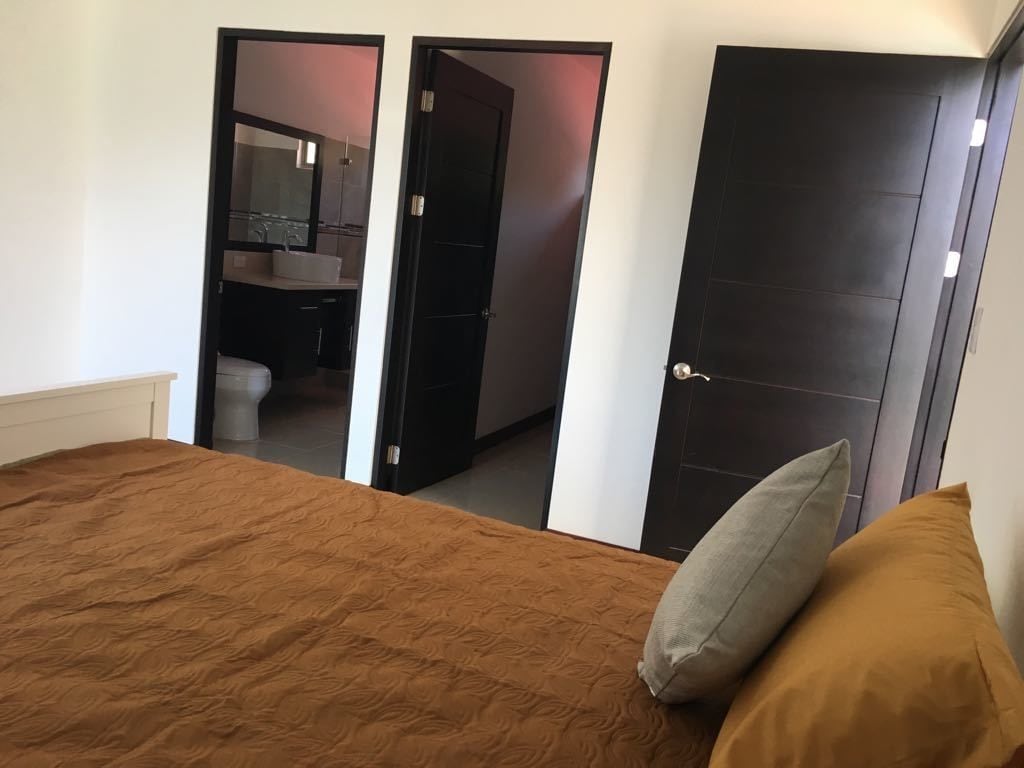 Quarto com cama, porta para um banheiro e um guarda-roupa.