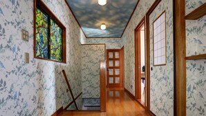 A hallway with floral wallpaper, wooden flooring, a stained glass window, and a ceiling with a cloud design. - Japan Countryside Atami (Atami)