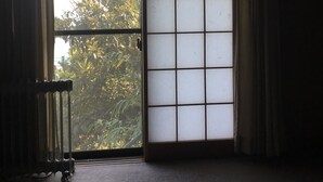 A room with a large window featuring a grid pattern, a radiator, and a view of greenery outside. - Japan Countryside Atami (Atami)