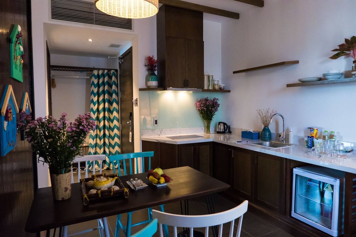 Una cocina moderna con comedor, que incluye un refrigerador empotrado, un lavamanos y una mesa de comedor con sillas.