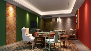 A modern room with a pool table, green and red walls, and a herringbone-patterned floor.