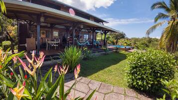 Relax by the pool in a serene outdoor setting surrounded by lush greenery and tropical plants.