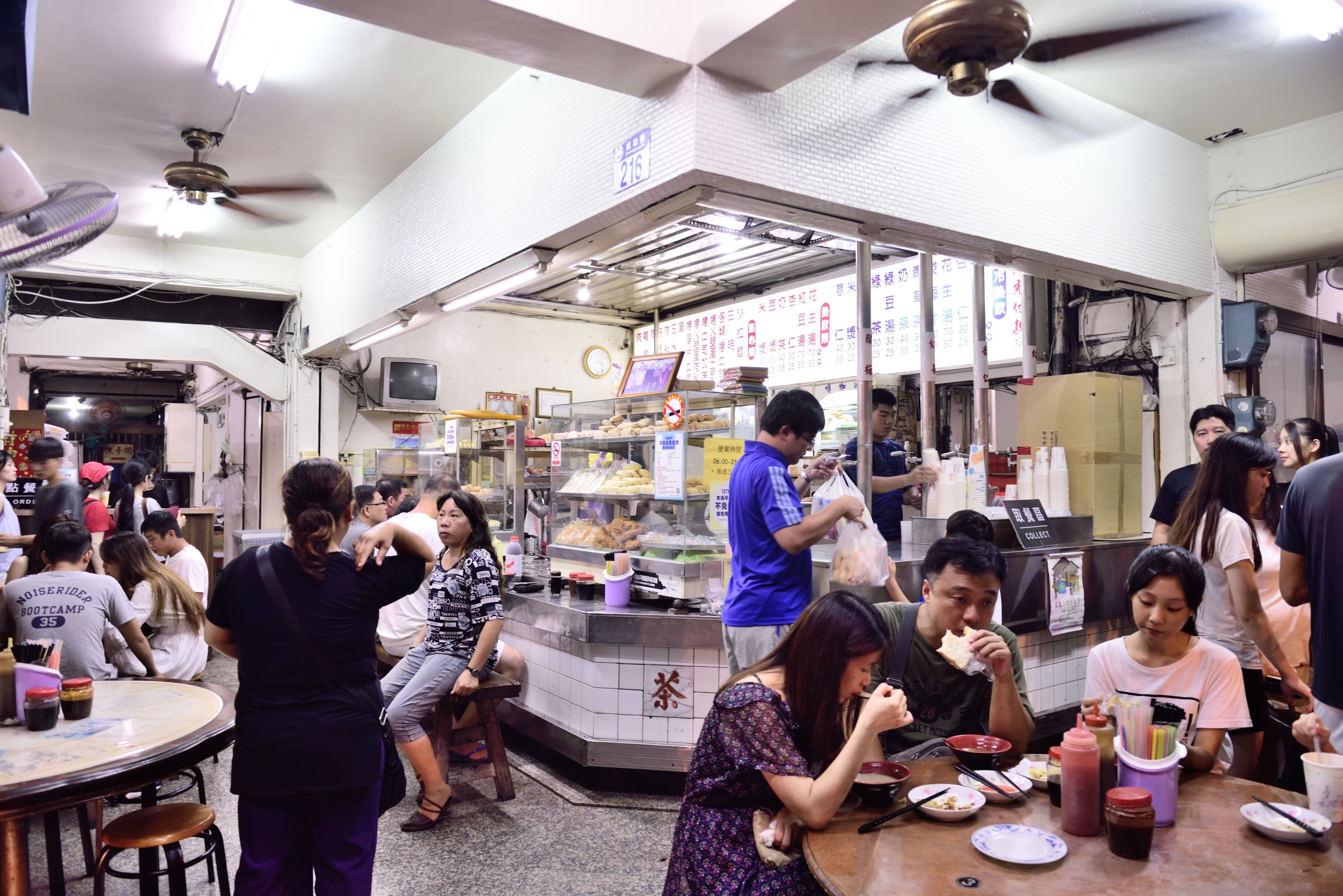 A busy indoor dining area with multiple tables and patrons.