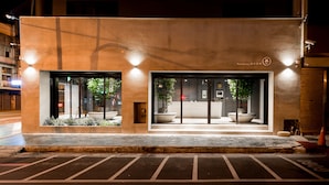 A hotel entrance with a modern design, featuring a reception desk, large potted plants, and a security camera. - Wountain hotel (Hualien City)