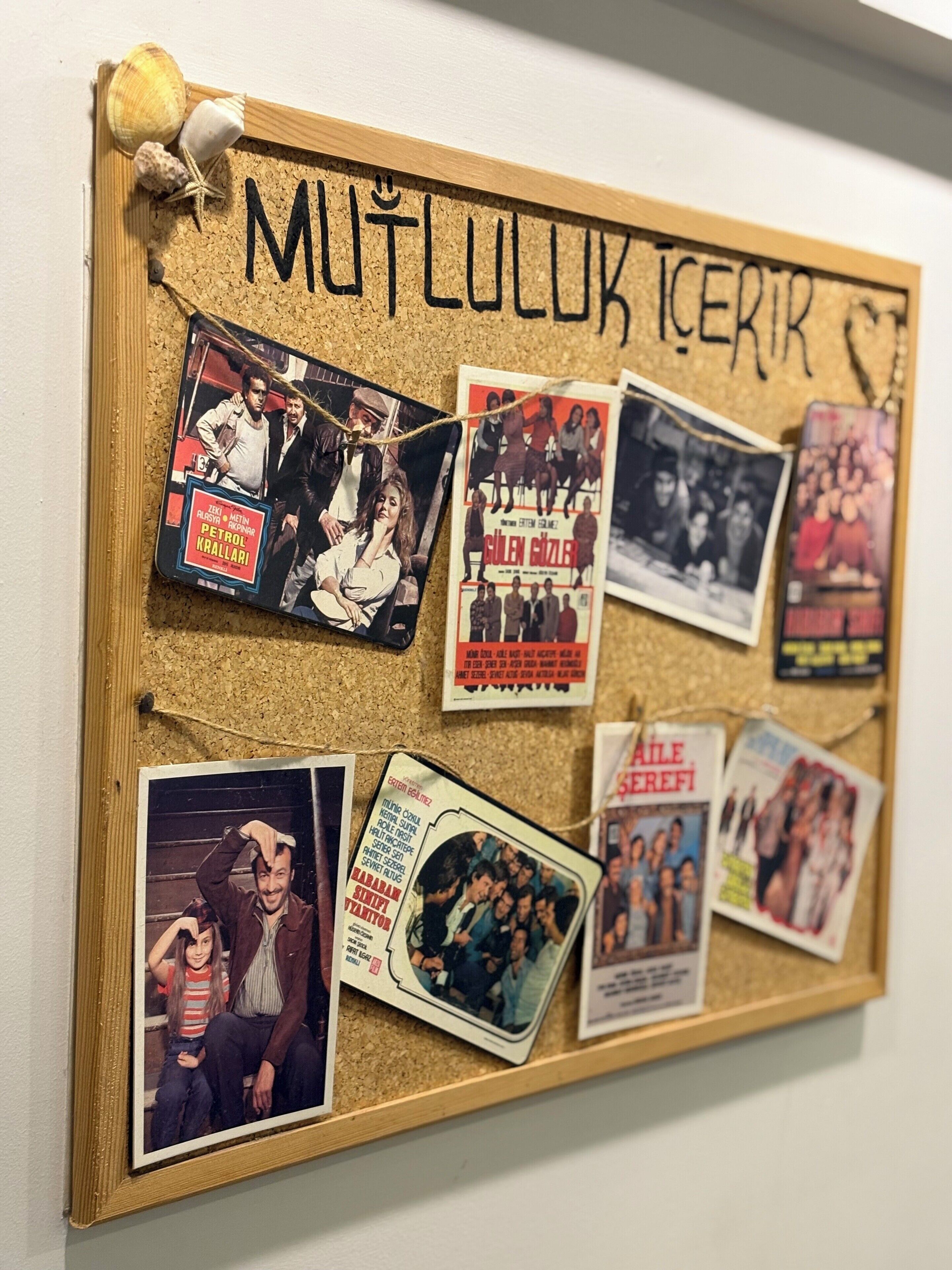 A corkboard with various movie posters and a wooden frame.