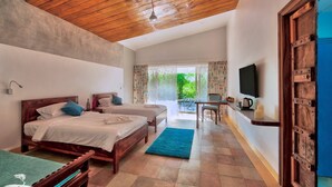 A room with two beds, a TV, and a dining area with a table and chairs. - Red Earth Tadoba (Chandrapur)