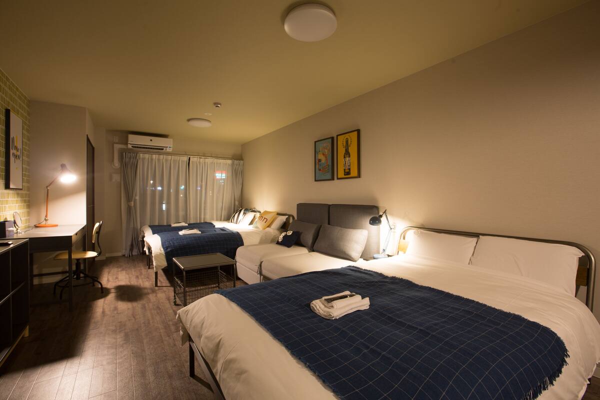 A hotel room with two beds, a desk, and a chair.
