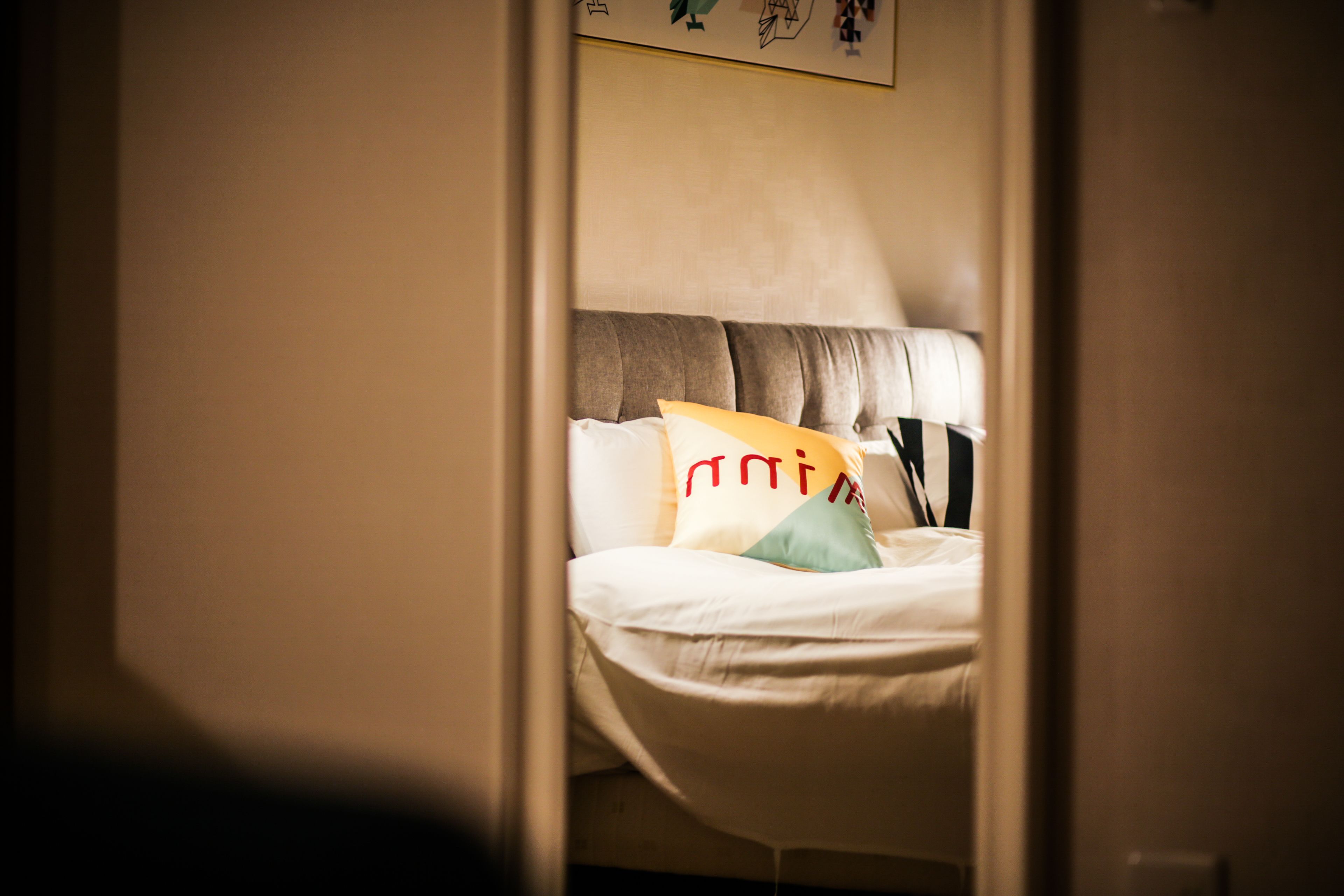 A bedroom with a bed, pillows, and a headboard.