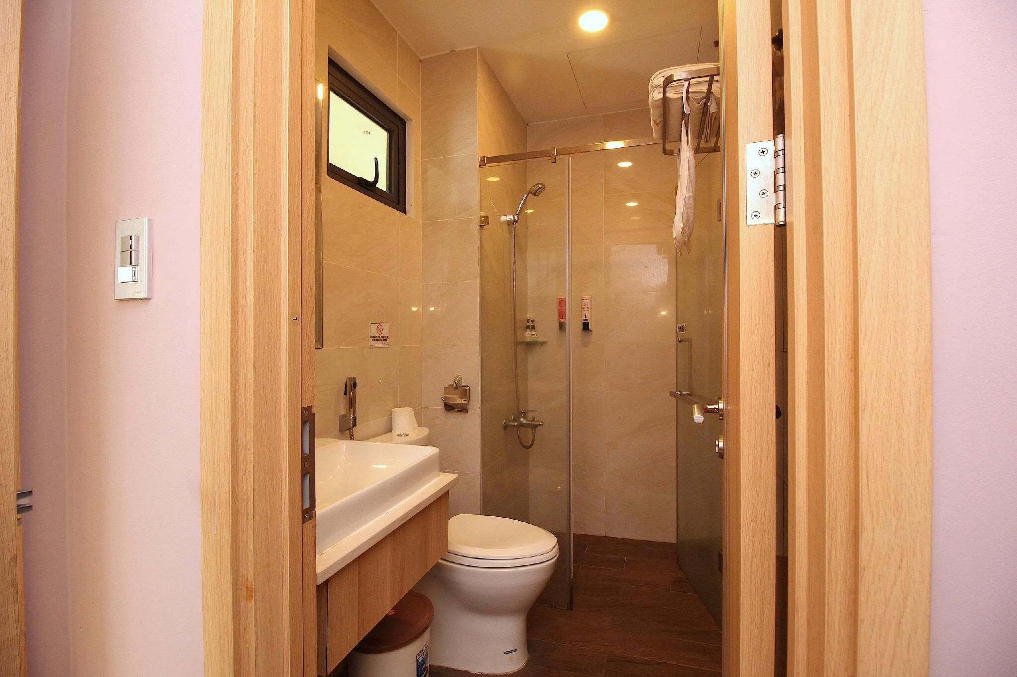 Een kleine badkamer met toilet, wastafel en douche.