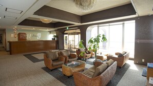 A spacious lobby with wicker furniture, a reception desk, and large windows allowing natural light. - RYUGU no TSUKAI (Higashiizu)