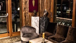Ein gemütliches Interieur mit Holzwänden, einem Marmor-Kamin und komfortablen Sitzmöglichkeiten.