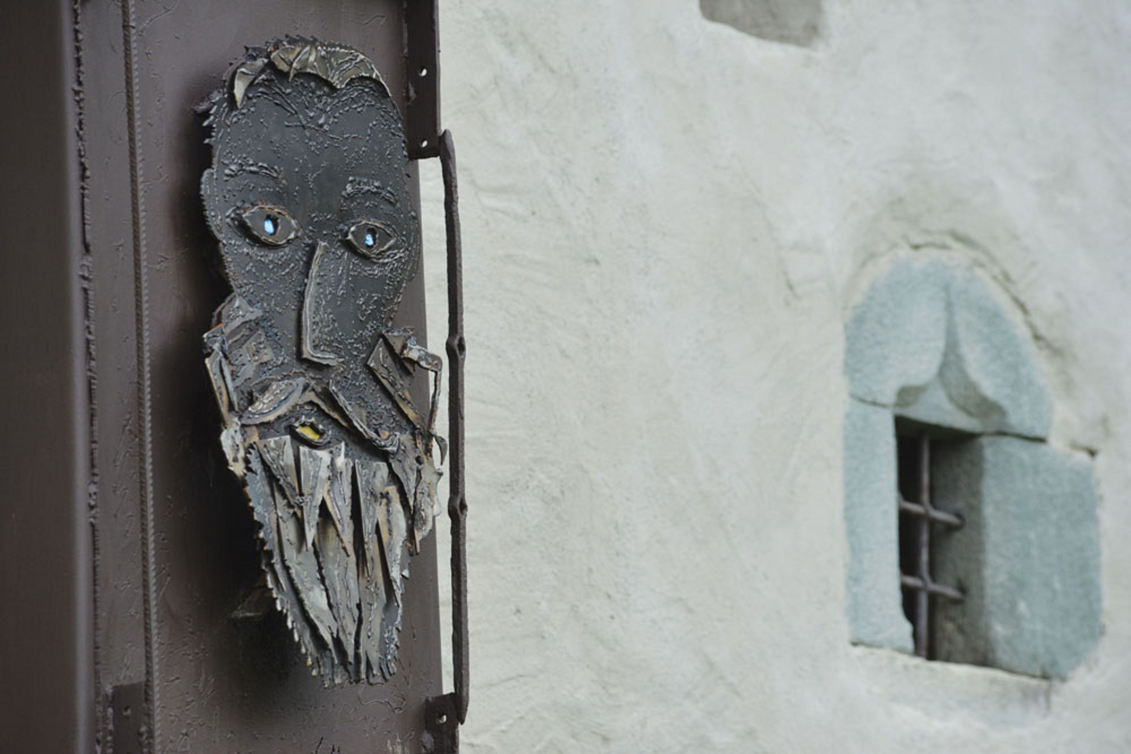 Una puerta rústica con una decoración facial texturizada y desgastada.