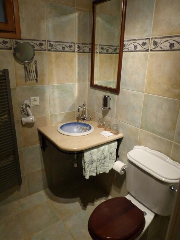 A bathroom with a sink, mirror, toilet, and towel rack. - Ta Xelidonakia (South Pelion)