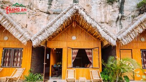 A bamboo bungalow with a thatched roof, two lounge chairs outside, and a small garden area. - Trang An Valley Bungalow (Tay Hoa Lu)