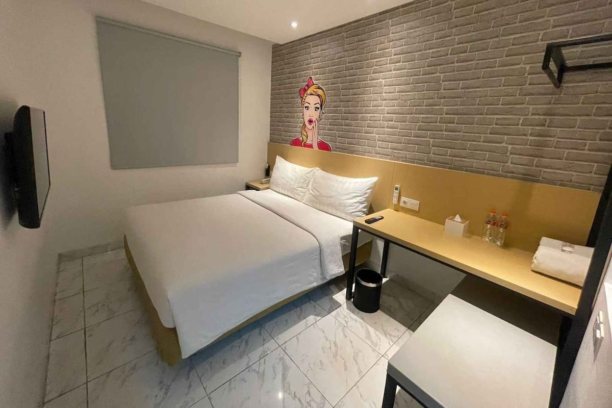Ein Hotelzimmer mit Bett, Nachttisch und einer Wand mit Ziegelmuster.