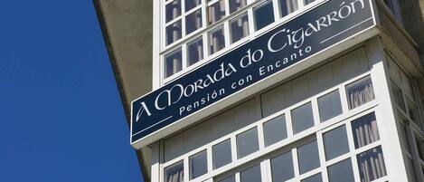 Un edificio con un letrero que dice 'A Morada do Cigarrão Pensión con Encanto'.