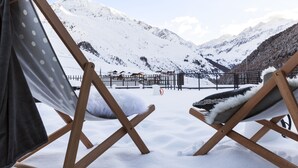 A snow-covered mountain landscape with a chair and a blanket in the foreground. - Langtauferer Hof (Curon Venosta)