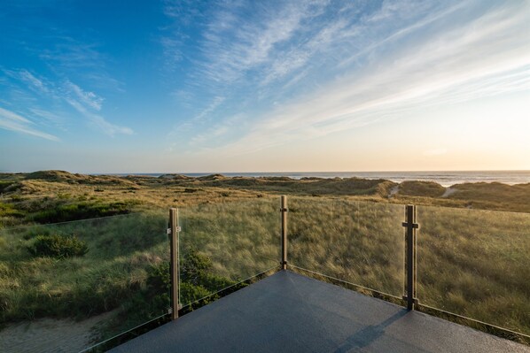 A paved viewing platform with a metal railing, overlooking a coastal landscape with dunes and a clear sky. - Oceanfront - The Manzanita Pool House (Manzanita)