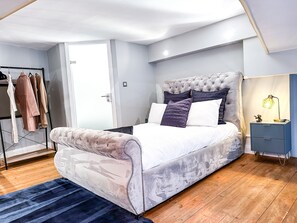 Relax in this inviting bedroom with a large bed, tufted headboard, and comfortable pillows.