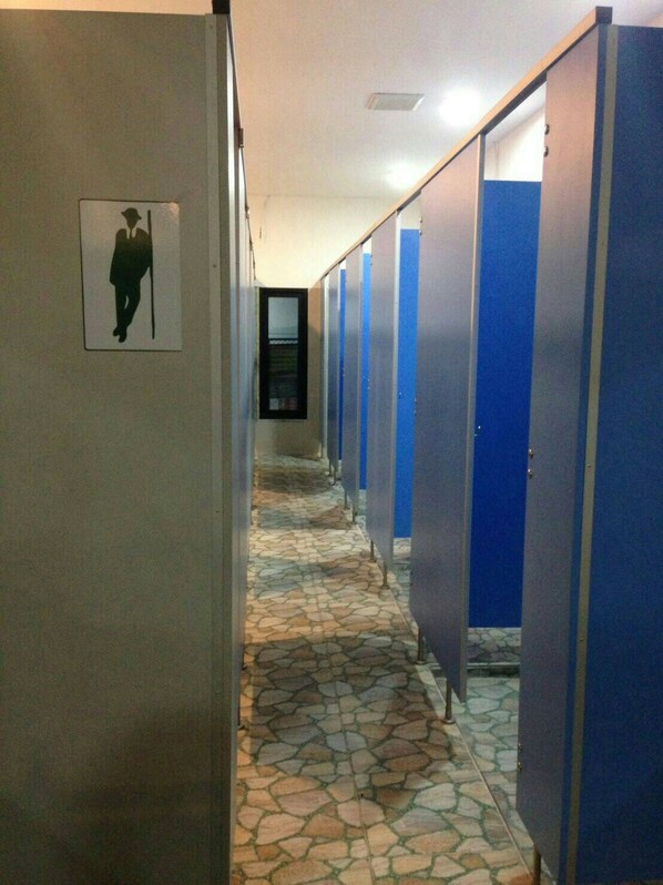 A corridor with blue stalls and a tiled floor. - Seahorse Lipe Hostel (Koh Lipe)