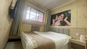 A hotel room with a bed, a nightstand, a TV mounted on the wall, a window with curtains, and a poster on the wall. - Beijing Huairou Pan Jia Yuan Hotel (Huairou)