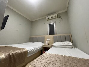 A hotel room with two beds, a window, an air conditioning unit, and a bedside table with a lamp. - Beijing Huairou Pan Jia Yuan Hotel (Huairou)
