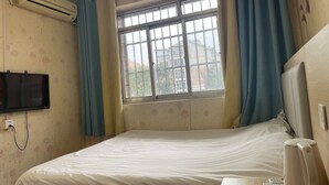 A room with a bed, an air conditioner, a window with curtains, and a TV mounted on the wall. - Beijing Huairou Pan Jia Yuan Hotel (Huairou)