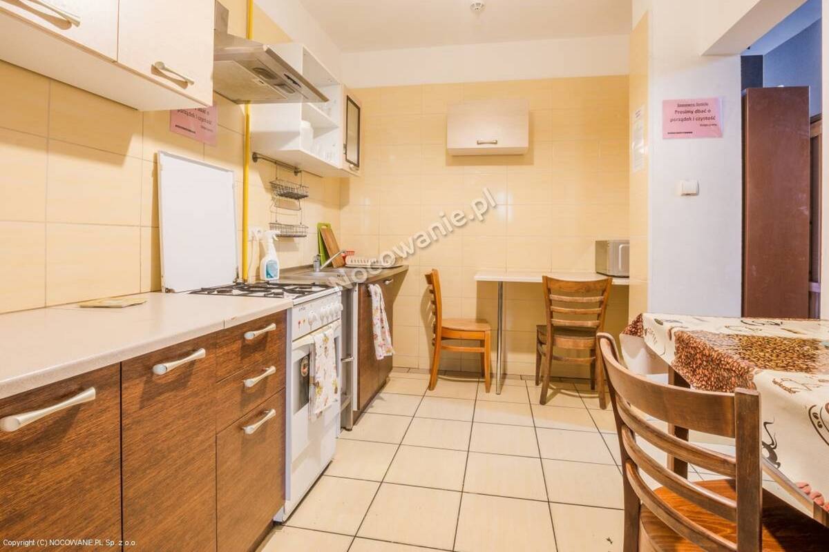 Une cuisine compacte équipée d’une cuisinière, d’un four et d’un petit coin repas avec deux chaises et une table.