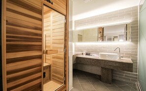 Un baño moderno con tocador de madera, un espejo grande y un lavabo blanco.