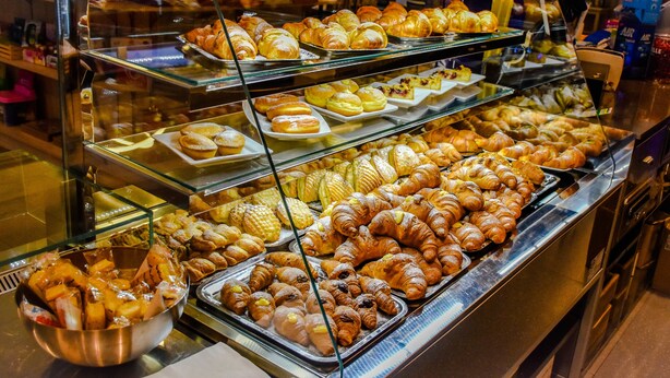 Una vitrina de pastelería con diversas opciones de productos horneados.