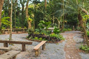 Un sentier de jardin agrémenté de bancs et d’une table en bois.