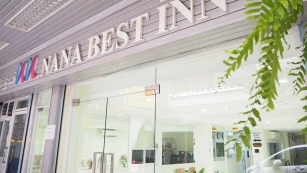 Exterior da Nana Best Inn, com placa visível, janelas amplas e design moderno.