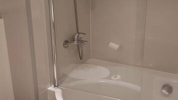 A modern bathroom with a glass-enclosed shower, a white bathtub, and a toilet.