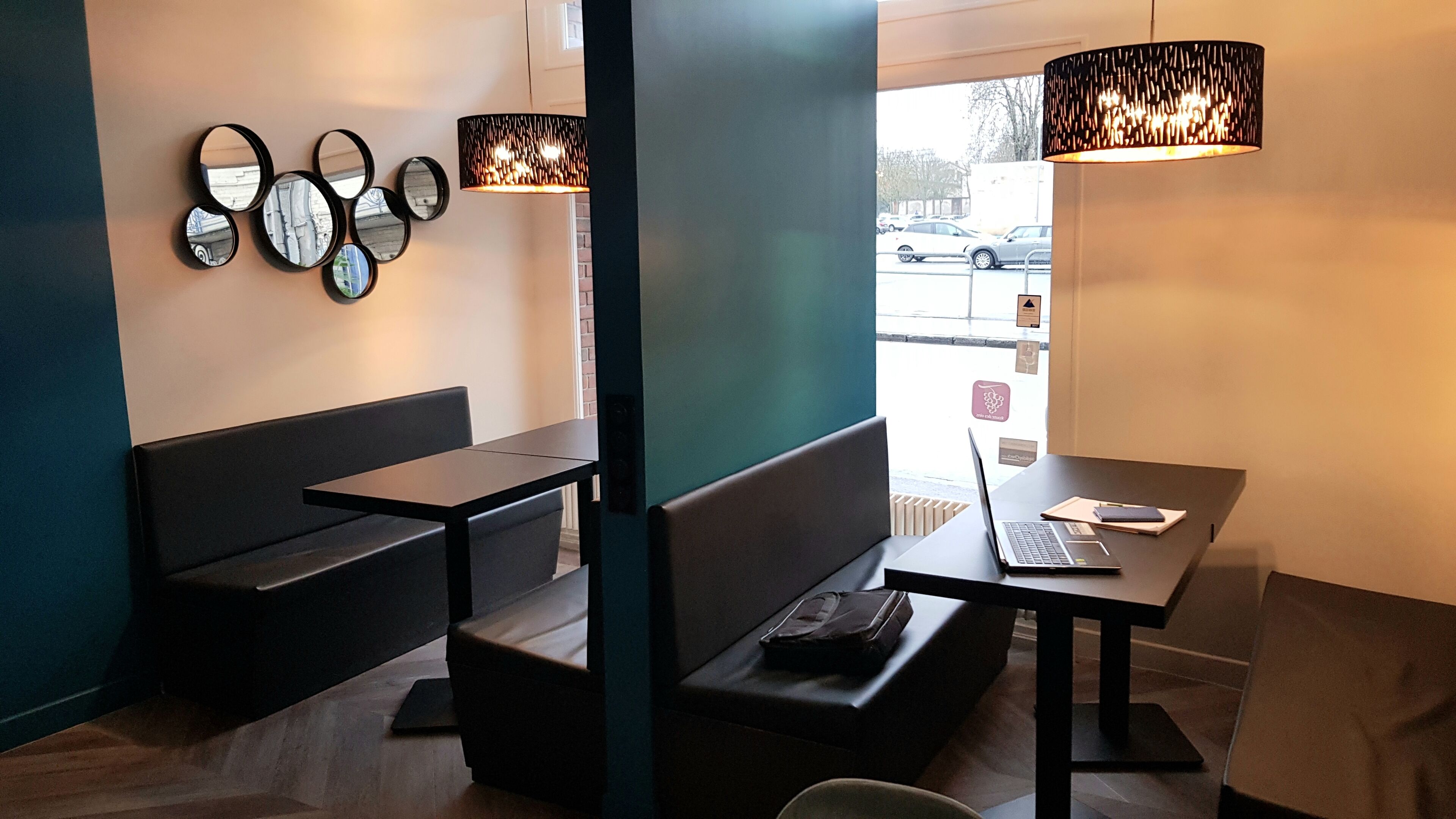 Un intérieur moderne avec un espace salon comprenant un banc et une table sur laquelle se trouve un ordinateur portable.