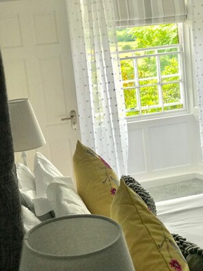 A room with a bed, a lamp, and a window with curtains. - Old School House (Ambleside)