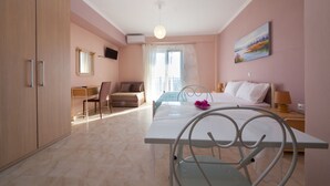Habitación de hotel con cama, escritorio, silla, armario y un cuadro en la pared.
