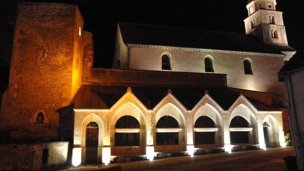 A historic building with a prominent tower and arched windows. - Le Puits Fortifie (Salives)