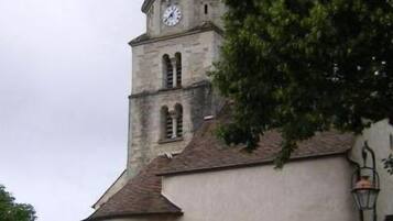 Una iglesia con un campanario alto que tiene un reloj.