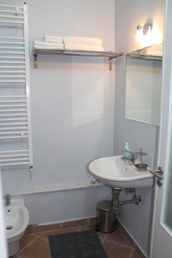 A bathroom with a white sink, a bidet, a towel rack, and a mirror. - L'Iris B&B (Lucca)