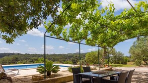 A covered outdoor dining area with a pool, surrounded by greenery and hills in the background. - Son Fornes - Beautiful villa with pool and garden in Algaida (Algaida)