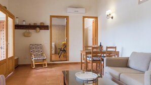 A living room with a sofa, a glass-top coffee table, and a dining area with chairs and a table. There is a washing machine in the background, and a mirror on the wall. - Son Fornes - Beautiful villa with pool and garden in Algaida (Algaida)
