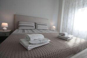 Deluxe kamer | Luxe beddengoed, een minibar, een kluis op de kamer, een bureau