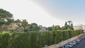 A parking lot with cars, a stone wall, and a building in the background. - Alla Vista Del Barocco (Lecce)