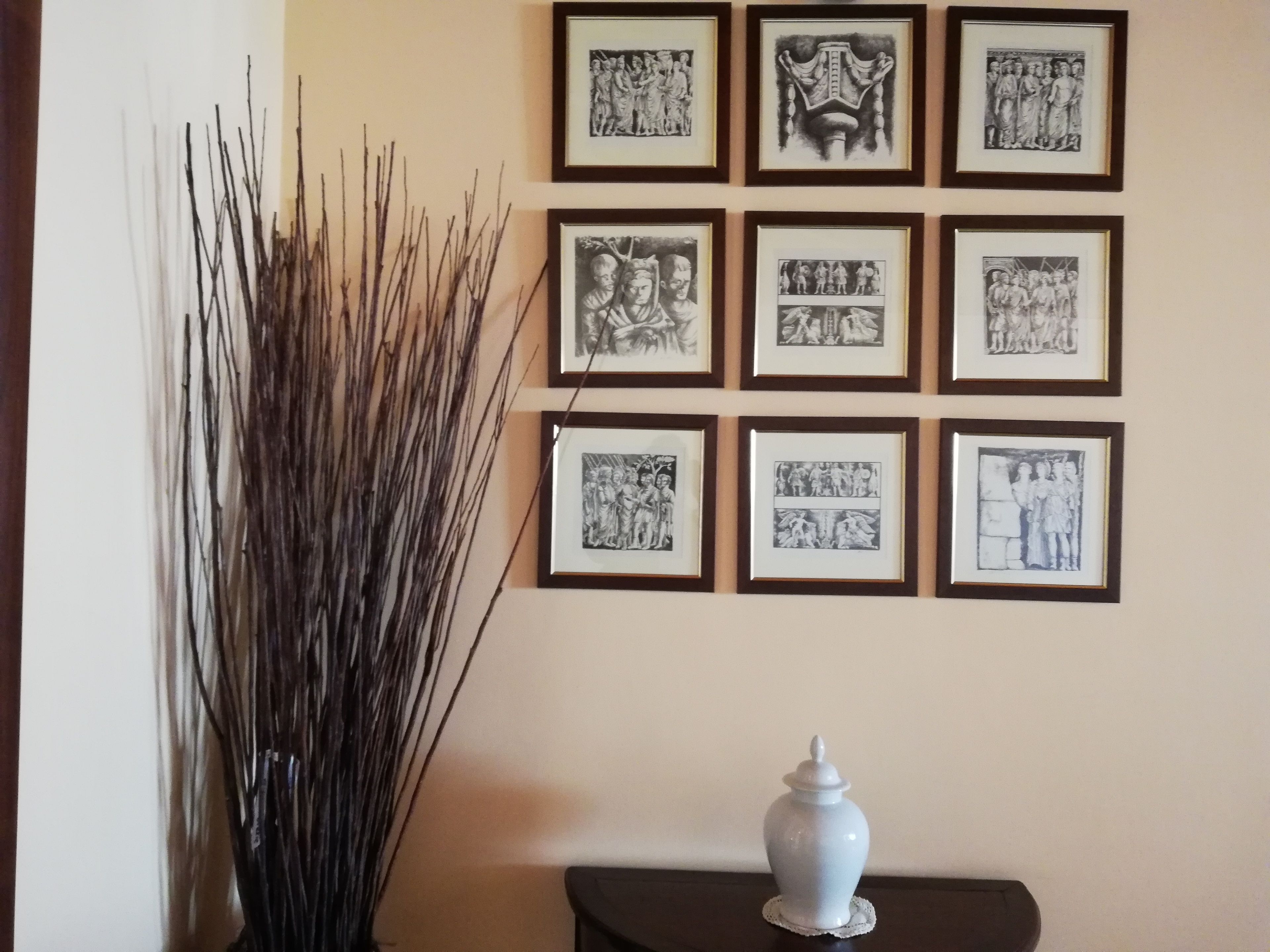 Pared con varias fotografías blanco y negro enmarcadas, dispuestas en forma de cuadrícula.